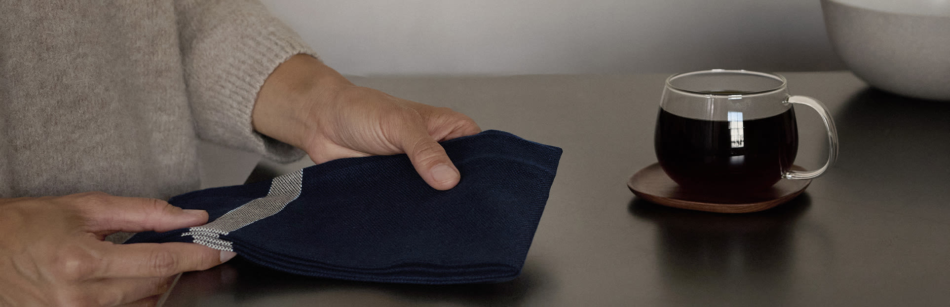 person holding towel with cup of coffee