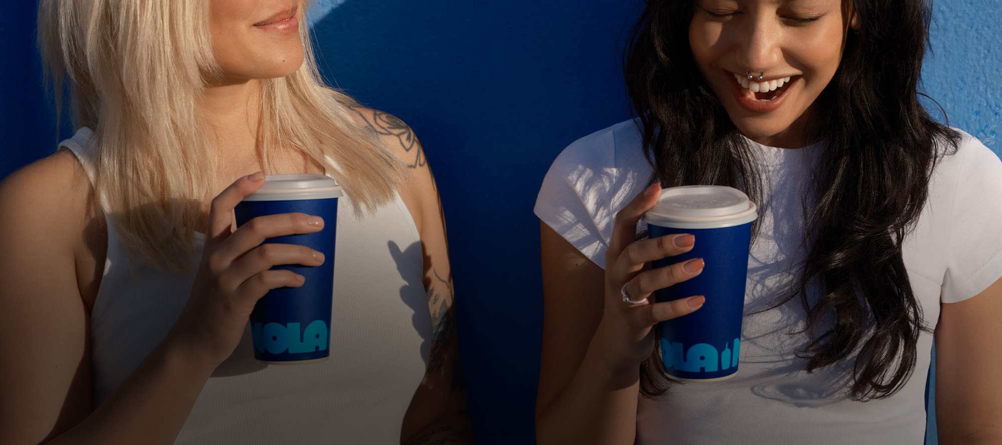 two people holding NOLA coffee cups