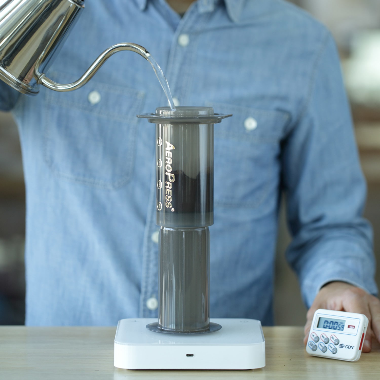 Water being poured into an Aeropress sitting on a scale.