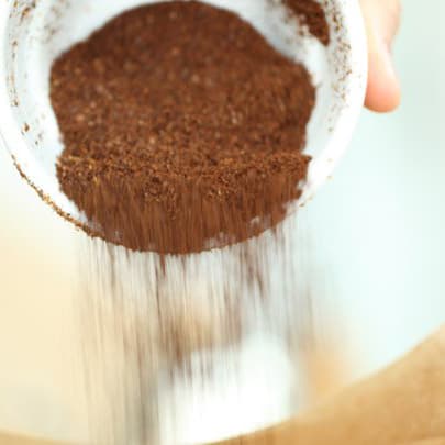 Coffee grounds being poured into a filter