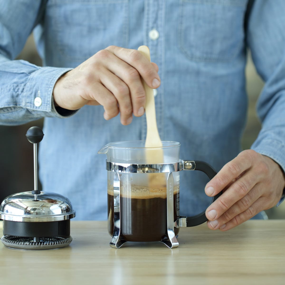 French press of coffee being stirred