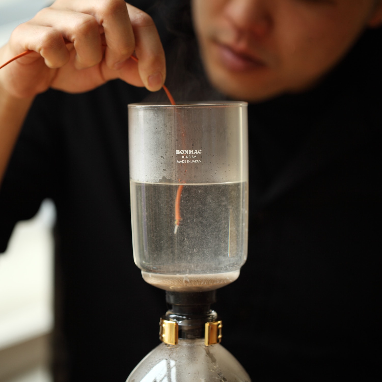 Siphon with a thermometer inserted into the water.