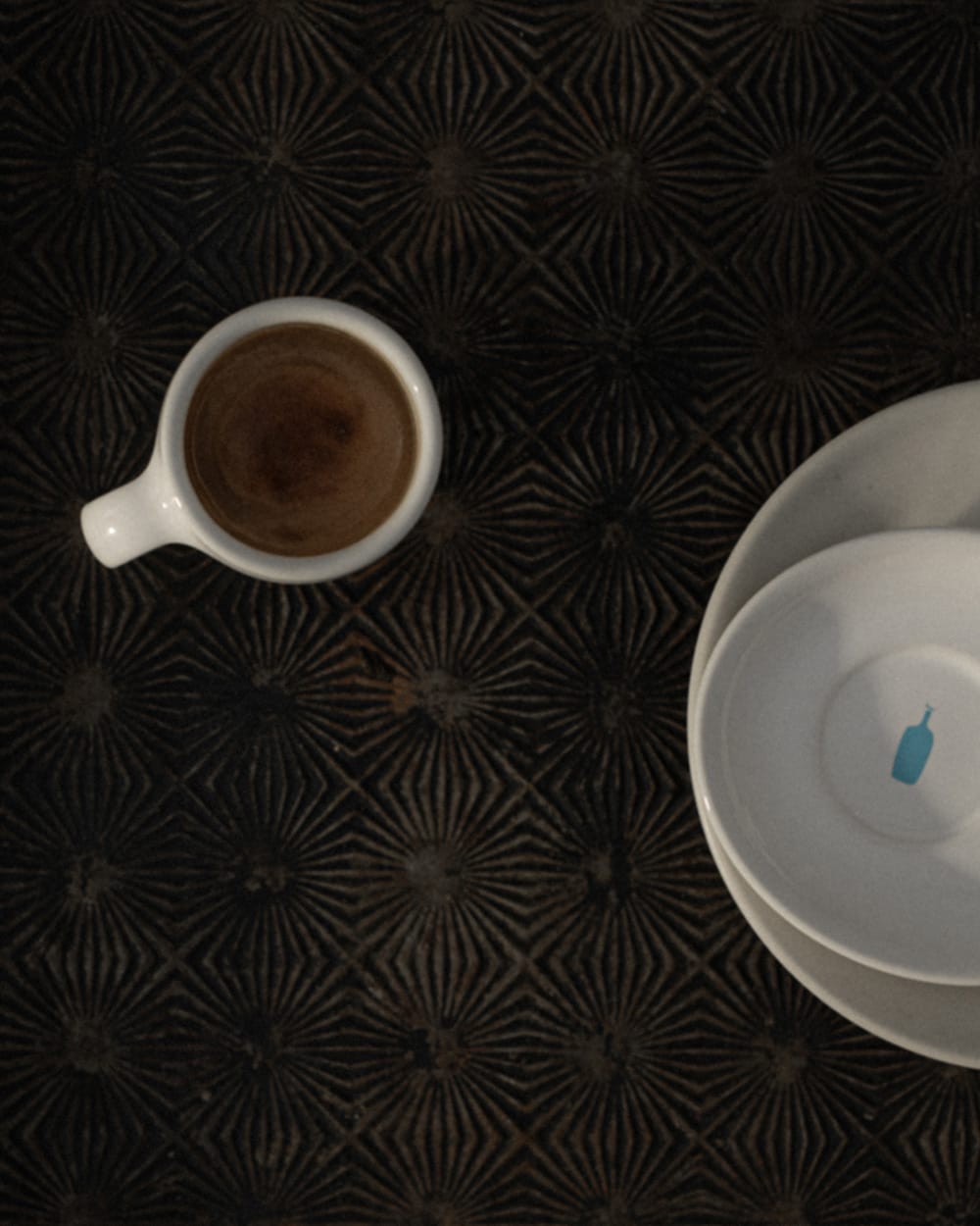 Espresso in a ceramic demitasse on a table.