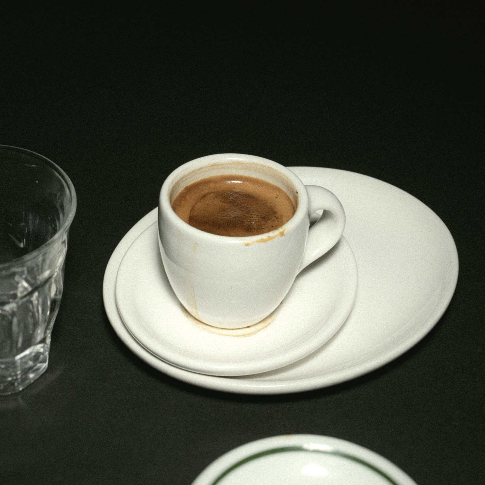 An espresso on a stack of saucers.