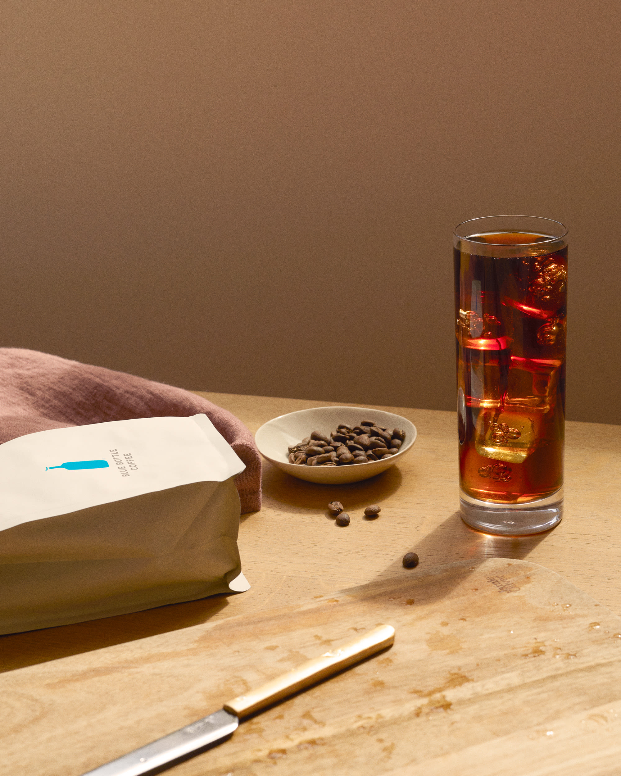 Hot Over Iced Coffee with whole coffee beans and Blue Bottle Coffee bag