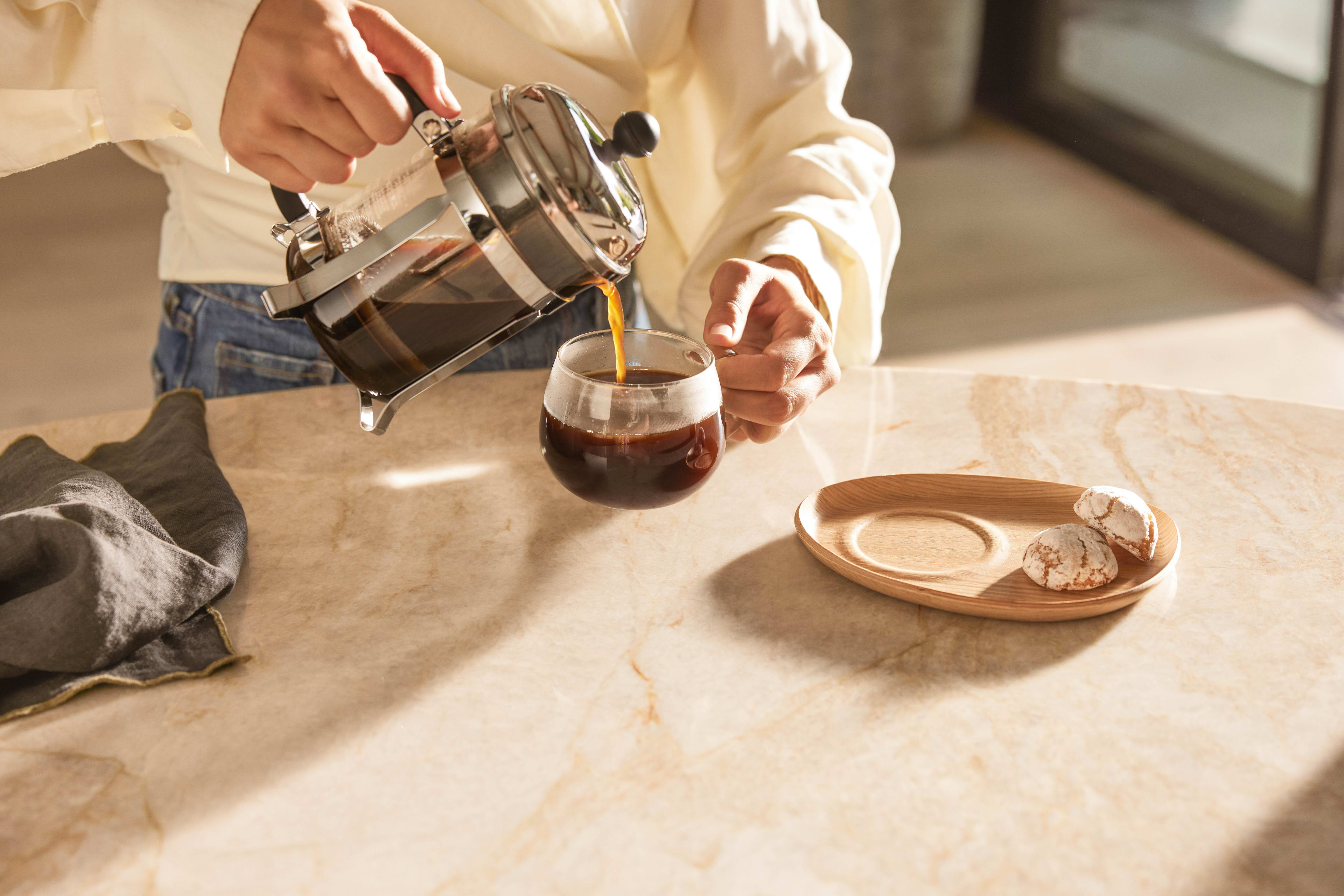 pouring coffee into the kinto cup cookie plate with cookies