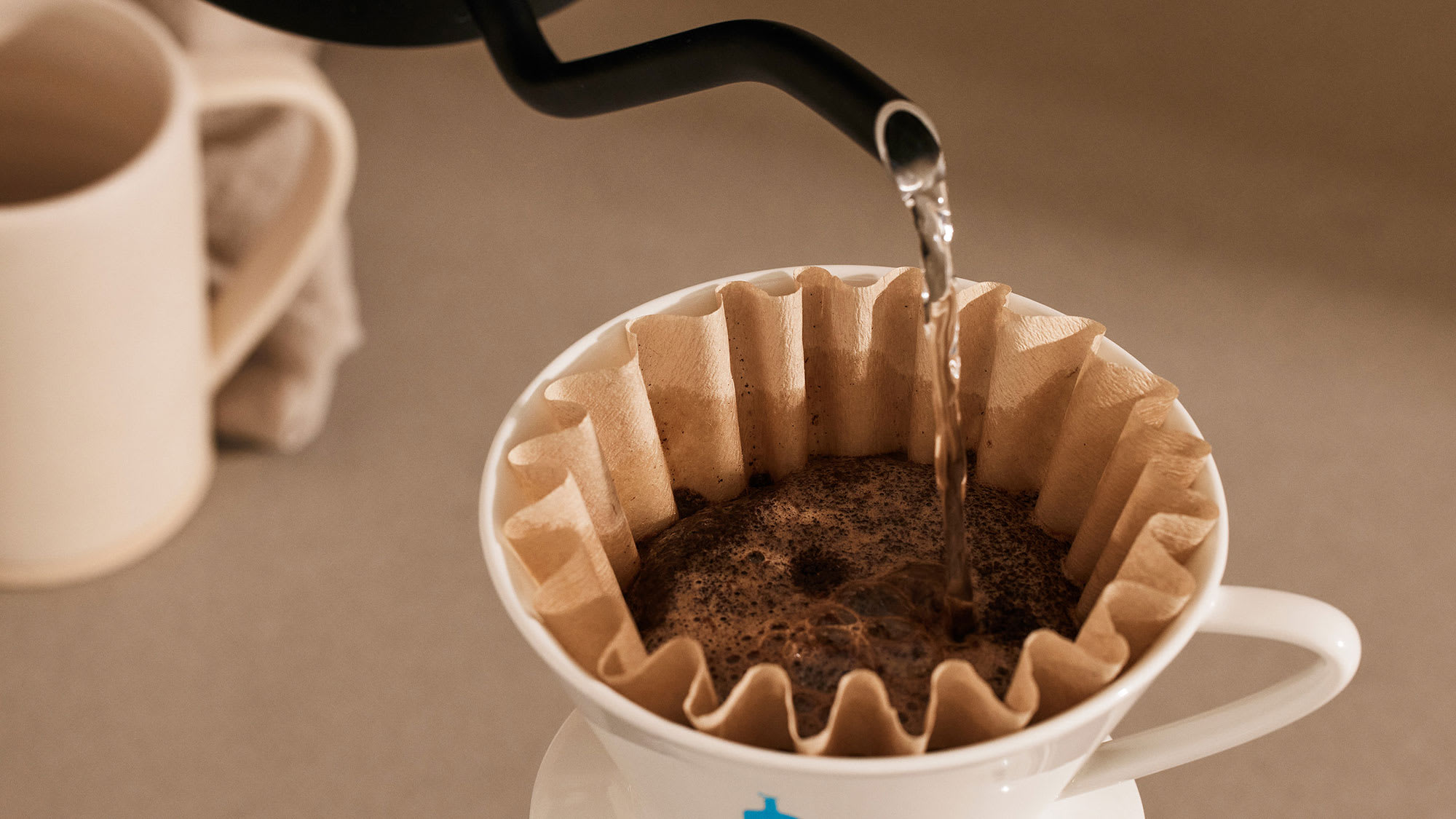 Coffee blooming inside of a blue bottle filter and dripper