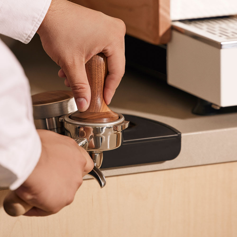 Espresso tamper being used to prepare a an espresso shot.