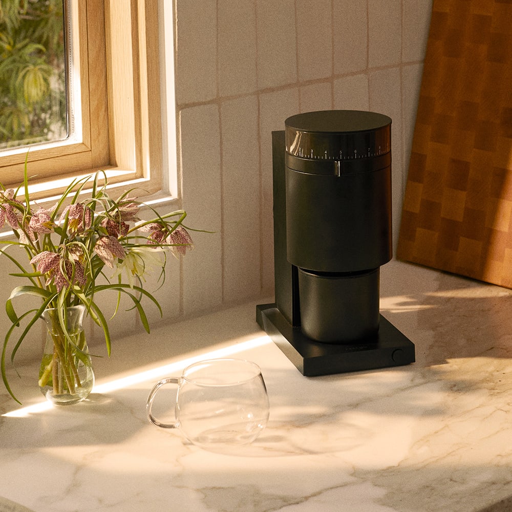 Fellow Opus Grinder on countertop with Kinto Glass Mug