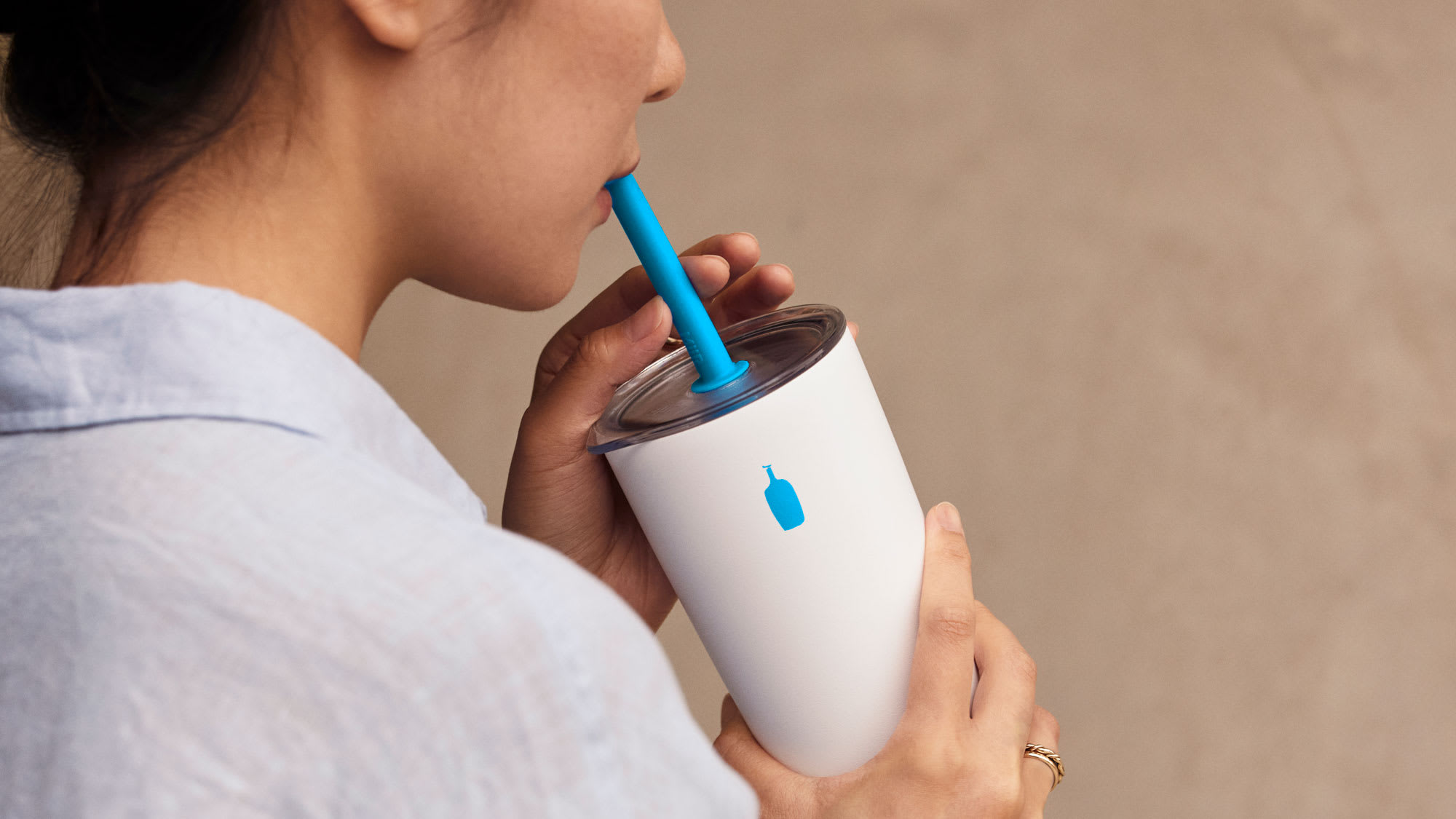 Person drinking from Miir Commuter Cup with Straw and Press Fit Lid. 