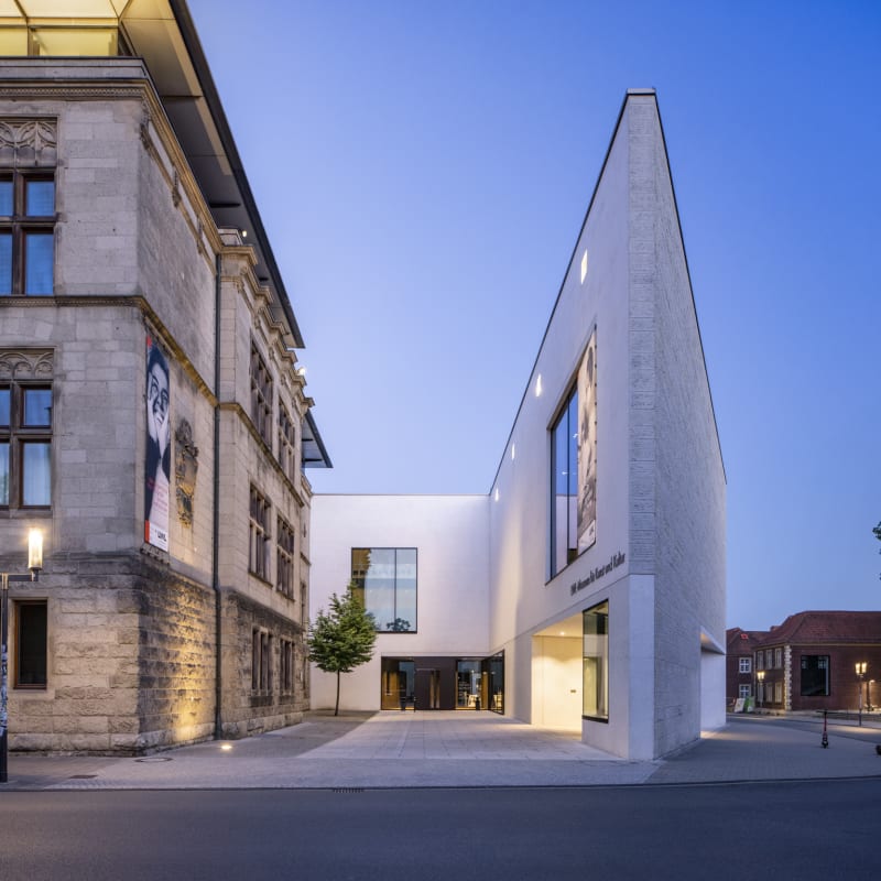 Das Foto zeigt eine Außenansicht des Museums am Domplatz. Zu sehen ist die markante Spitze des Neubaus und der Altbau des Hauses.