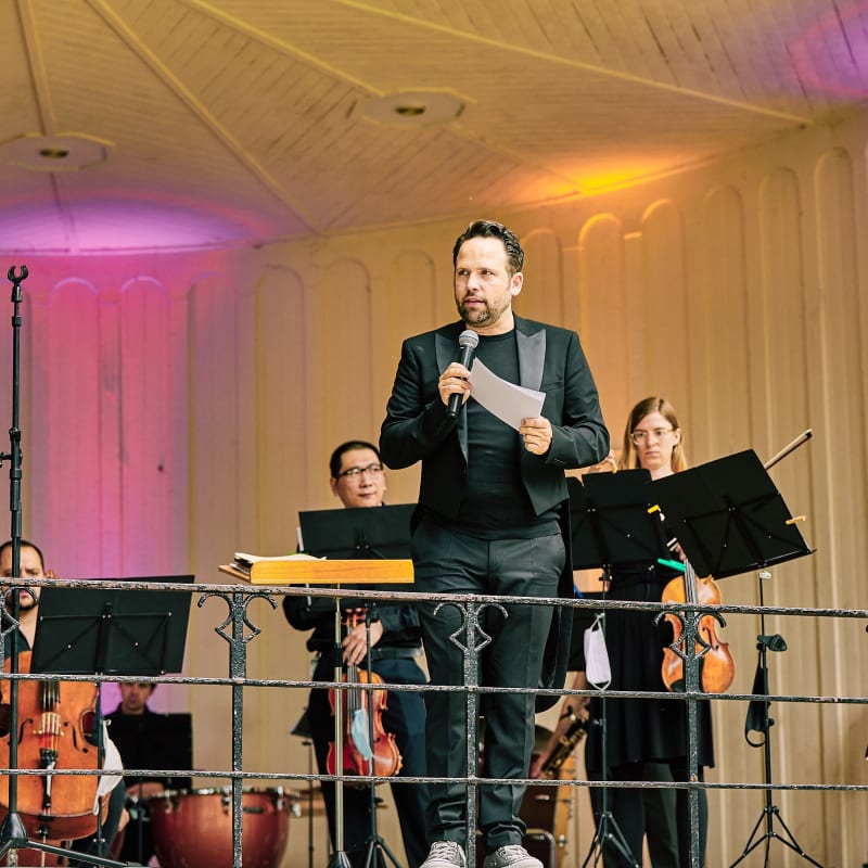 Christoph Tiemann moderiert ein Konzert der MikroPhilharmonie EinKlang