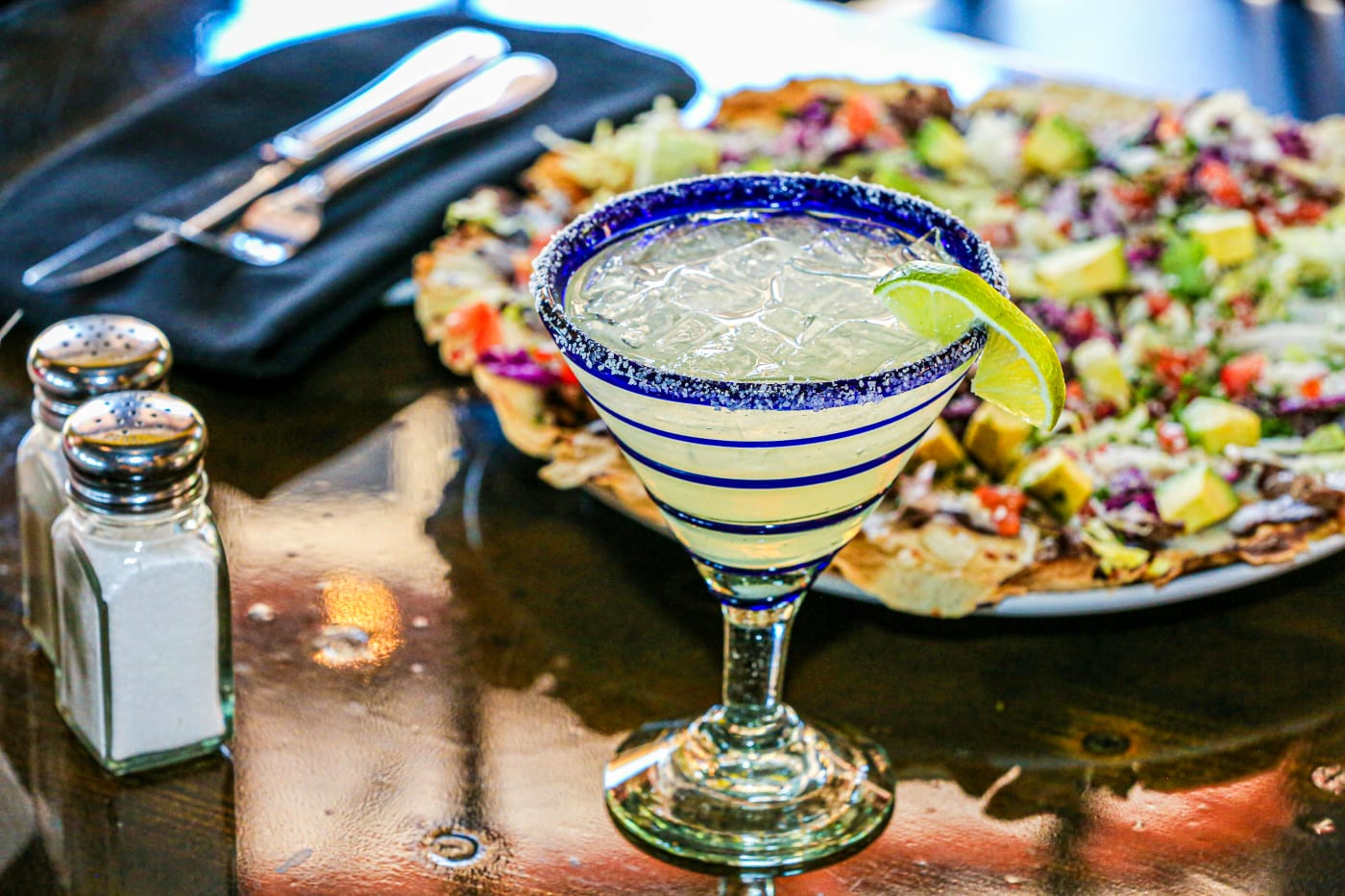 Margaritaglas med saltet kant og lime på bordet klar til servering, perfekt til festlig cocktailopskrift.
