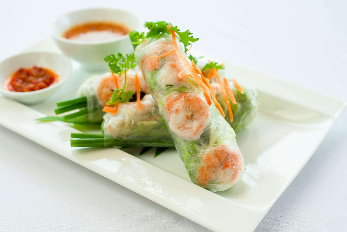 Vietnamese spring rolls with shrimp, served with fresh vegetables and a spicy soy dip for the summer party.