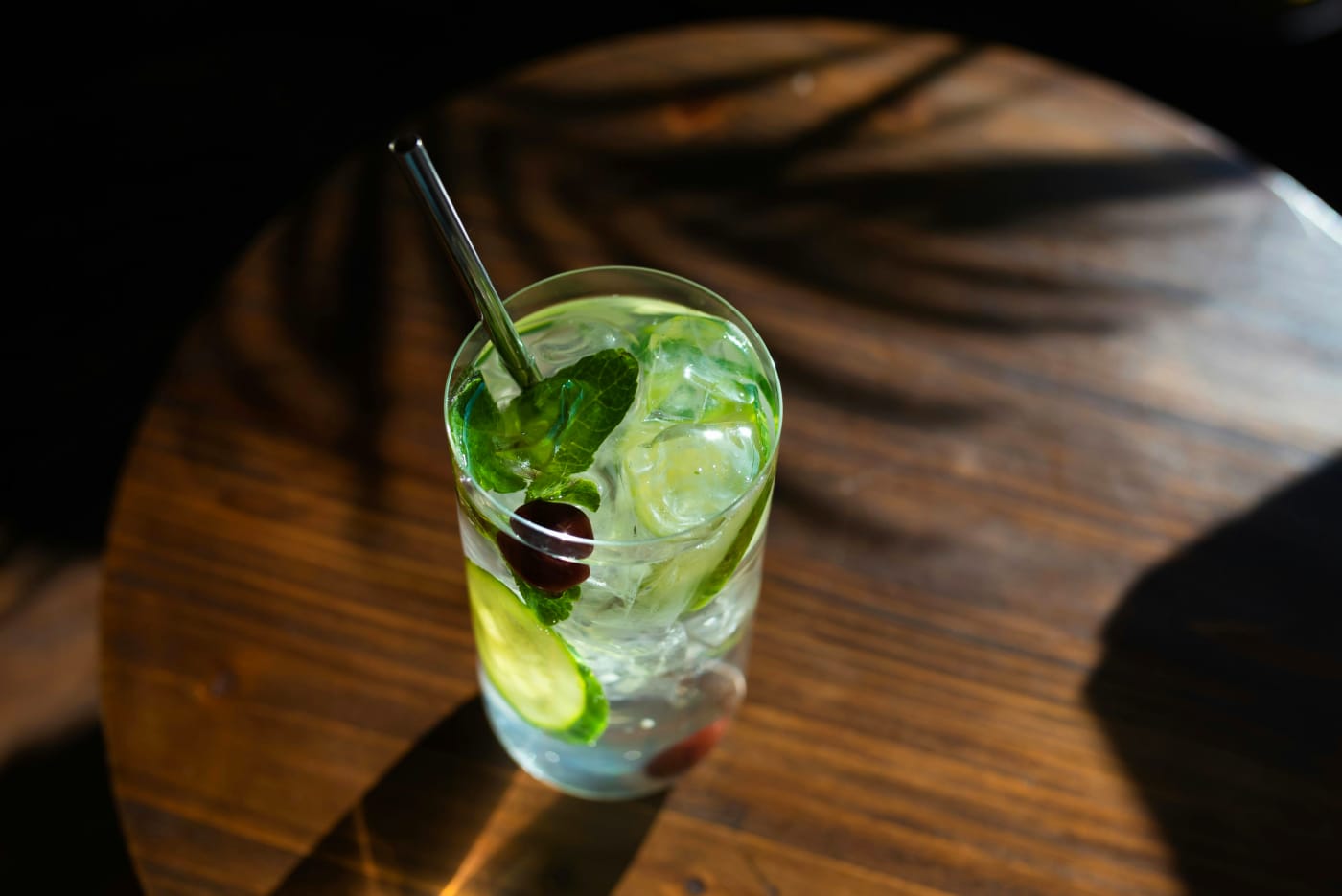 Klassisk mojito cocktail med mynteblade, lime og isterninger i et højt glas, perfekt til sommerens varme aftener.