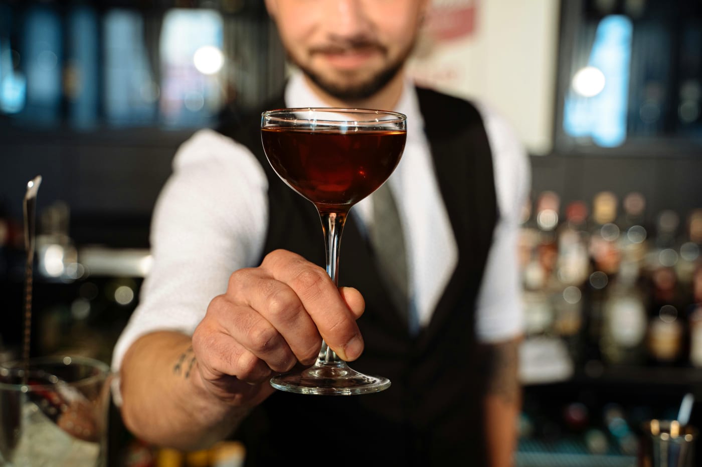 Bartender presents an elegant cocktail in a classic glass, perfect for impressive New Years celebrations.
