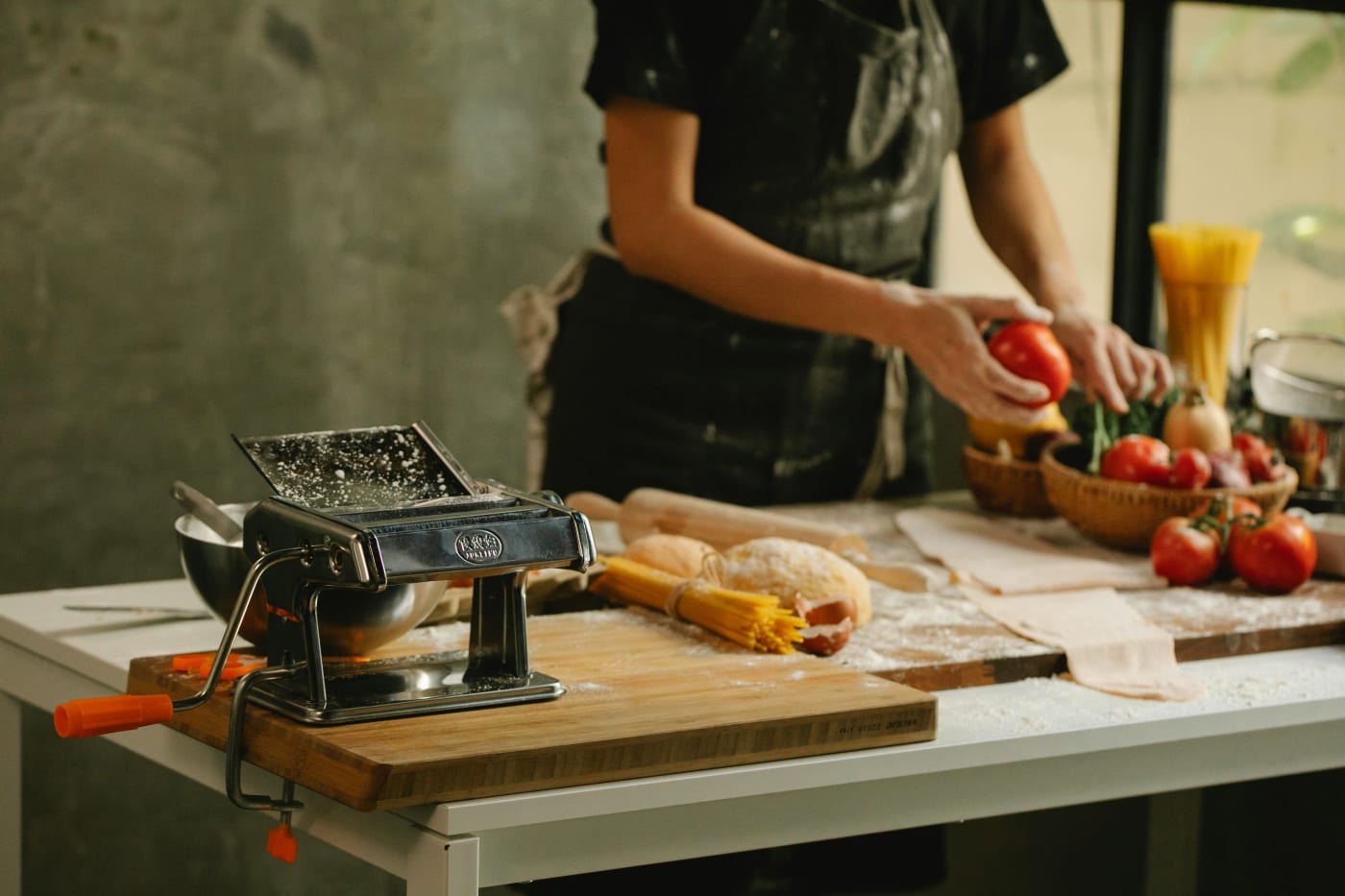 Private chef preparing fresh dishes at a table with ingredients, highlighting the benefits of hiring a chef for the confirmation.