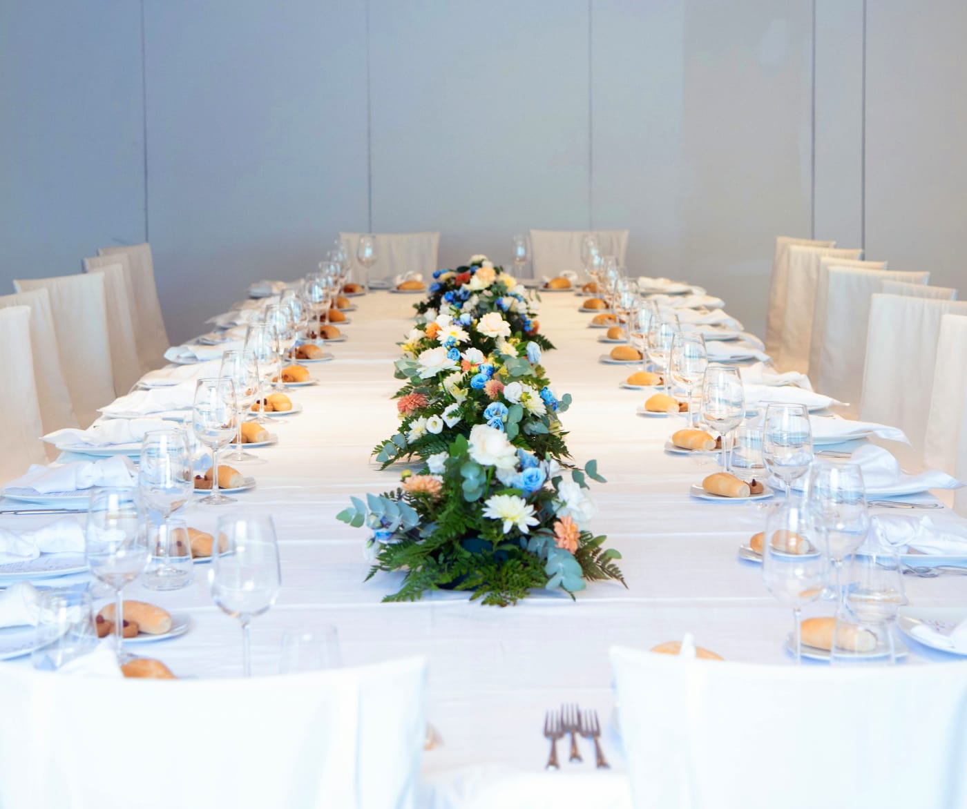 Elegant private dining table setup with covered places and floral decoration, ideal for a confirmation party.