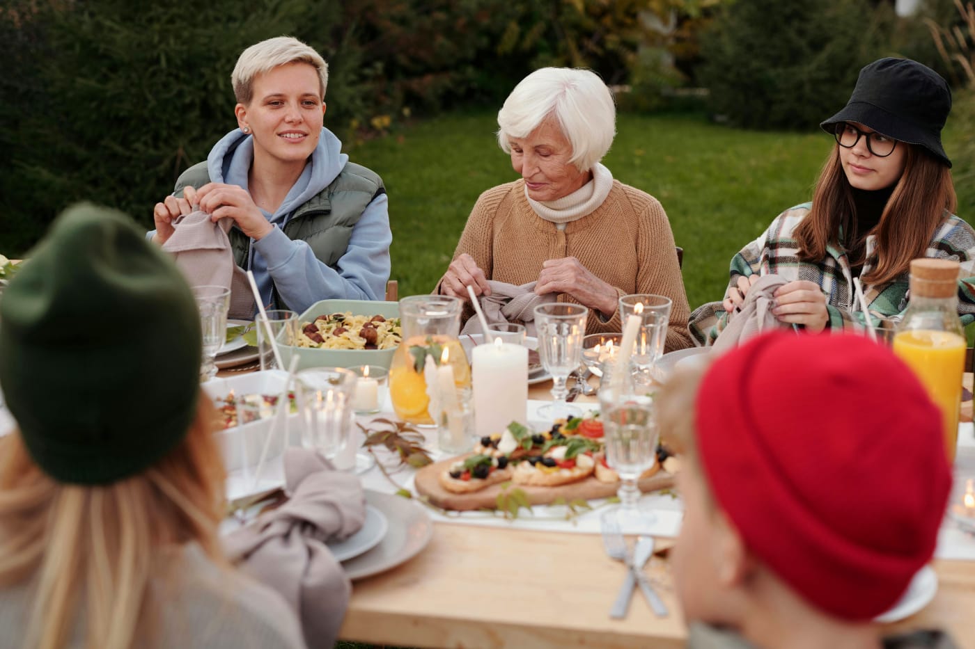 Group of people at a table during an outdoor company summer party with varied food accommodating diverse dietary preferences and allergies.