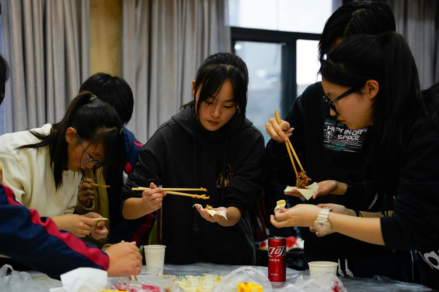 Participants at an interactive cooking station learning to cook together during a company summer party.