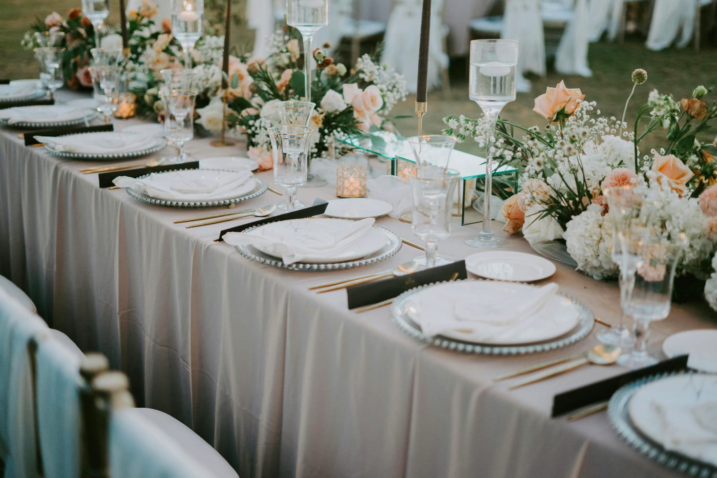 Elegant wedding table set for a classic three-course menu with floral decorations and fine plates.