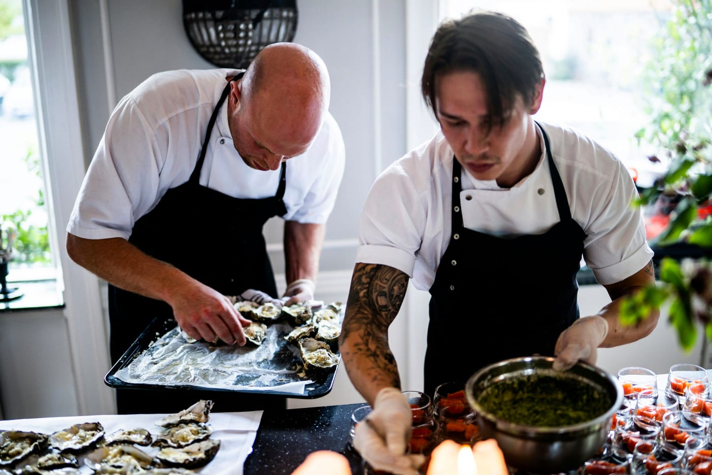 Professional chefs preparing a gourmet dinner reflecting ChefMes tailored menus for parties.