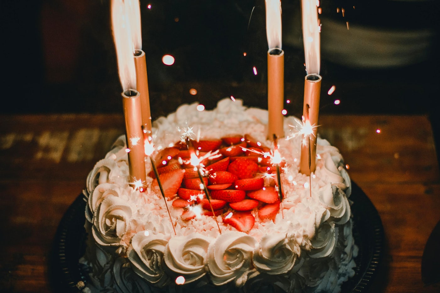 Festive birthday cake decorated with flames and fresh strawberries, symbolizing creative decoration and flavor in cake art.
