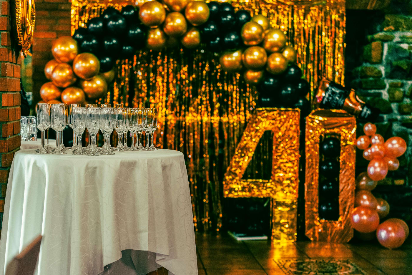 Festively decorated birthday venue with a 40th-anniversary theme, balloons, and a table with glasses ready for celebration.