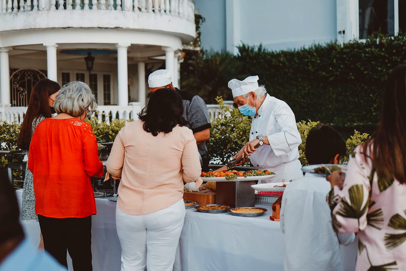 Professional chef tailors dishes to guests preferences at a festive outdoor birthday celebration.