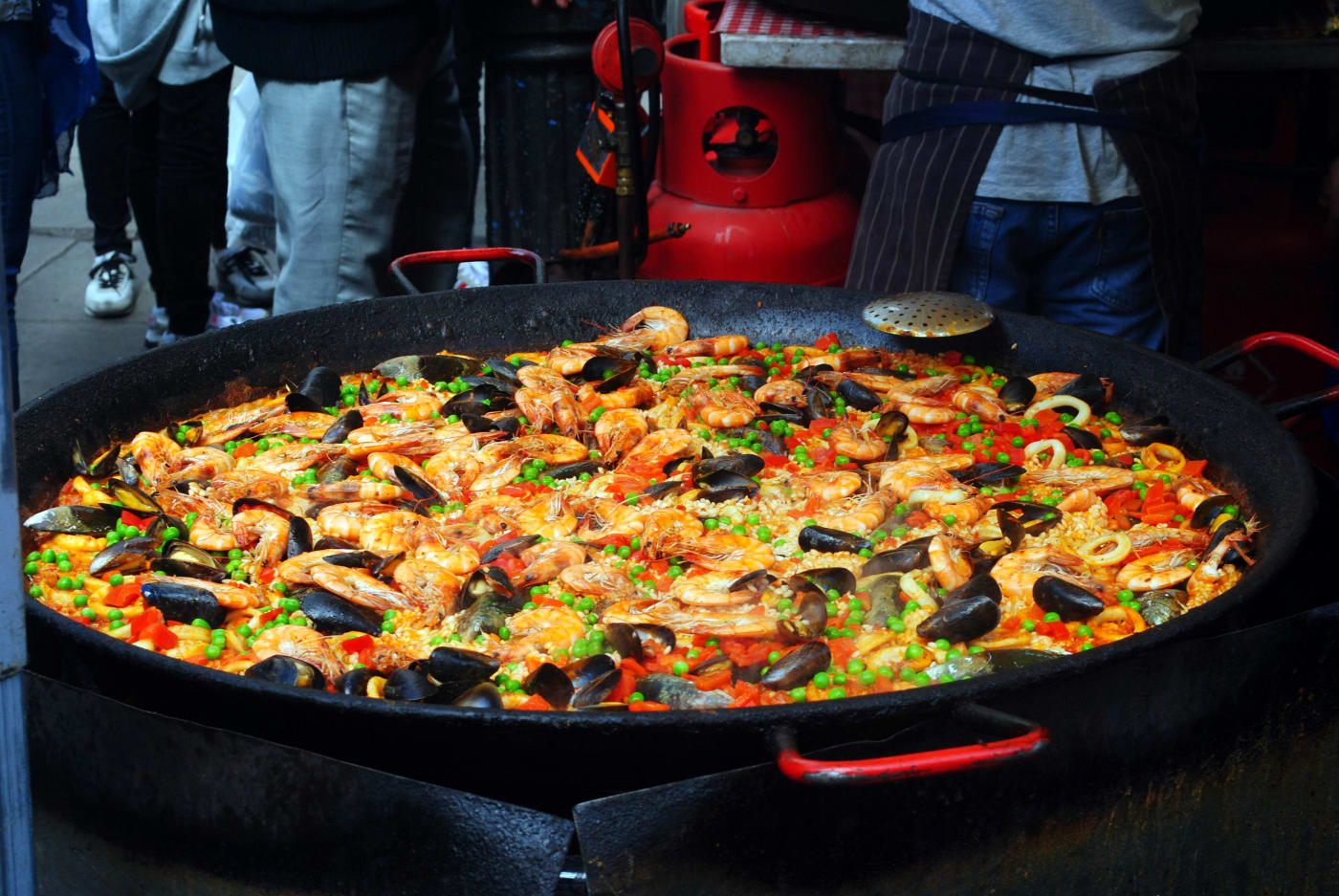Authentic Spanish paella with seafood, mussels, and vegetables in a large paella pan, highlighting Spanish food culture and the essence of the recipe.