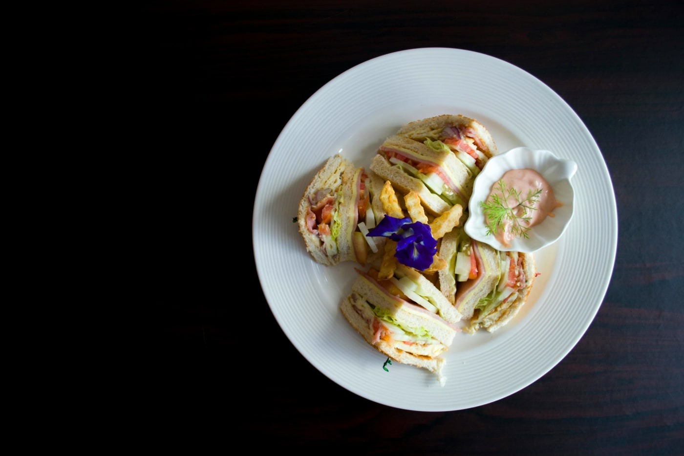 A plate with varied mini sandwiches, presented with decorative elements that highlight the versatility and appeal of small sandwiches to any taste.