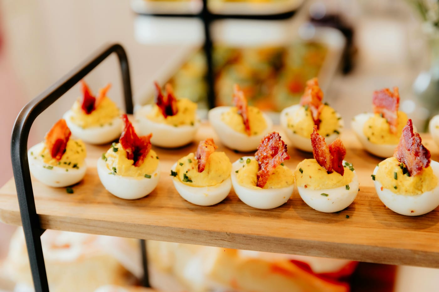 Delicious deviled eggs garnished with bacon and greens, presented elegantly on a serving dish, perfect for any festive occasion.