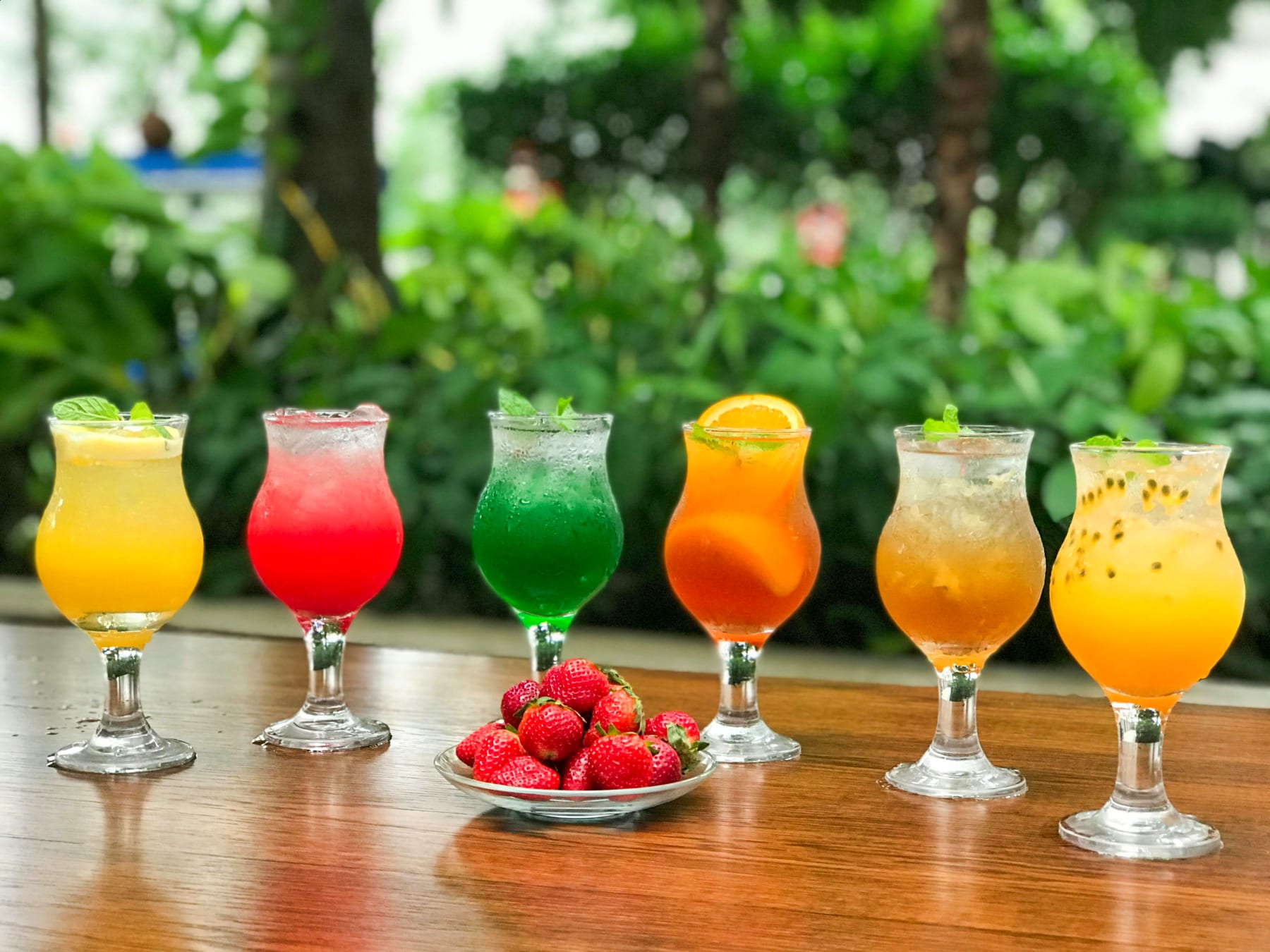 Farverige cocktails på rad med dekorationer, perfekte til at imponere gæster til din næste fest.