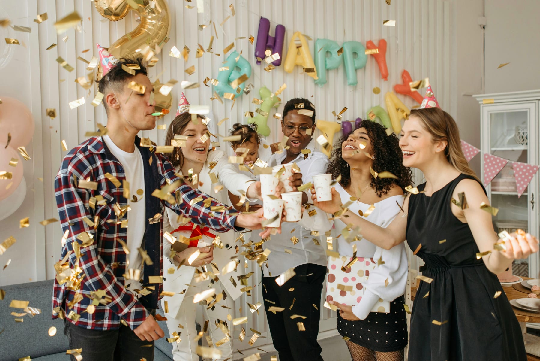 Happy people celebrate with confetti and drinks at a birthday party, perfect for tips on planning the ultimate party.