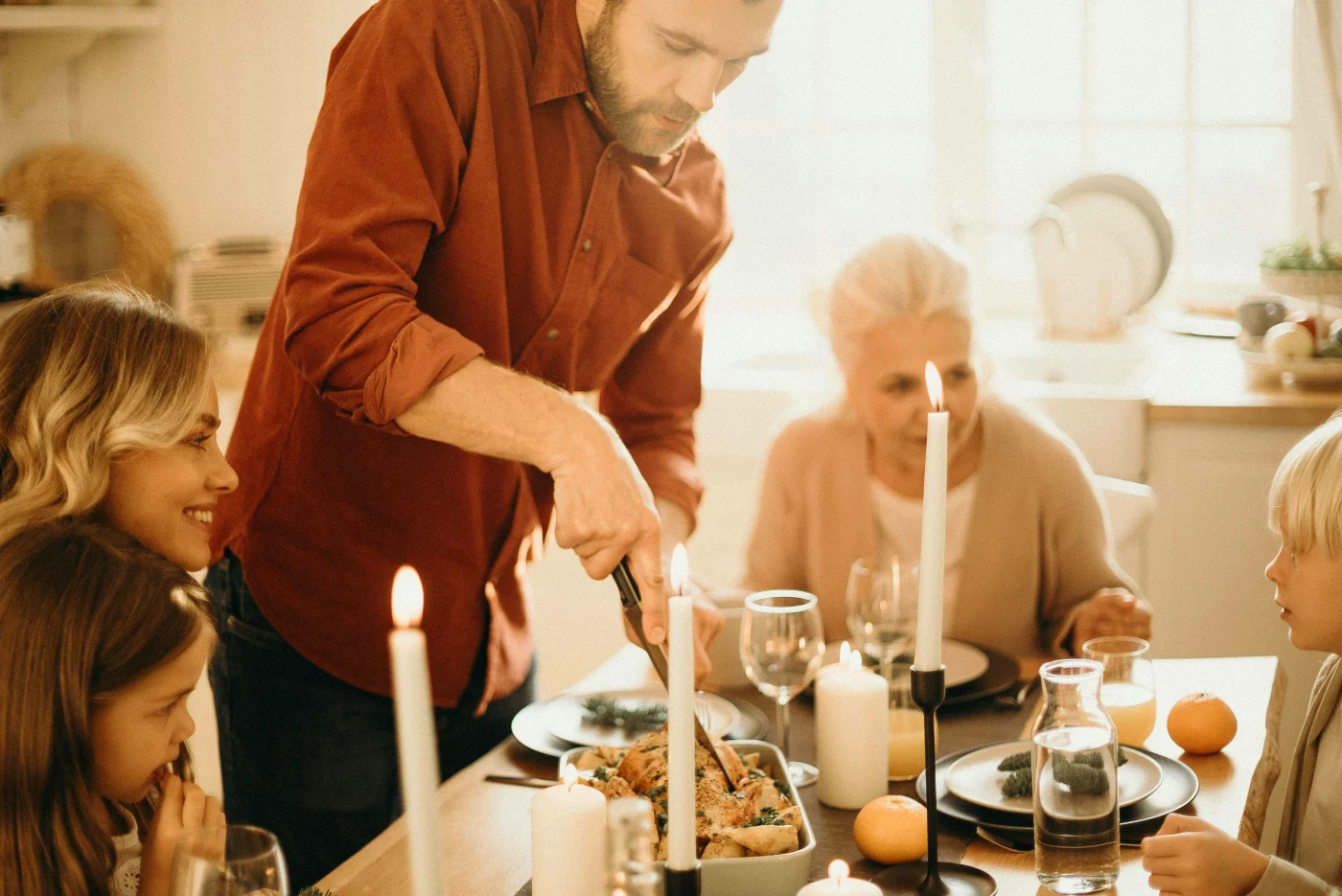 Familie samles omkring et flot dækket bord til påskefrokost, med levende lys og smilende ansigter, der udstråler hygge og forberedelse.