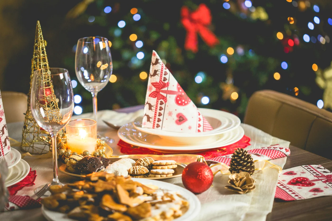 Festively laid Christmas table with candles, Christmas decorations, and classic Christmas decor. Perfect for the article on unforgettable Christmas lunch menus that mix tradition and modern flavors.