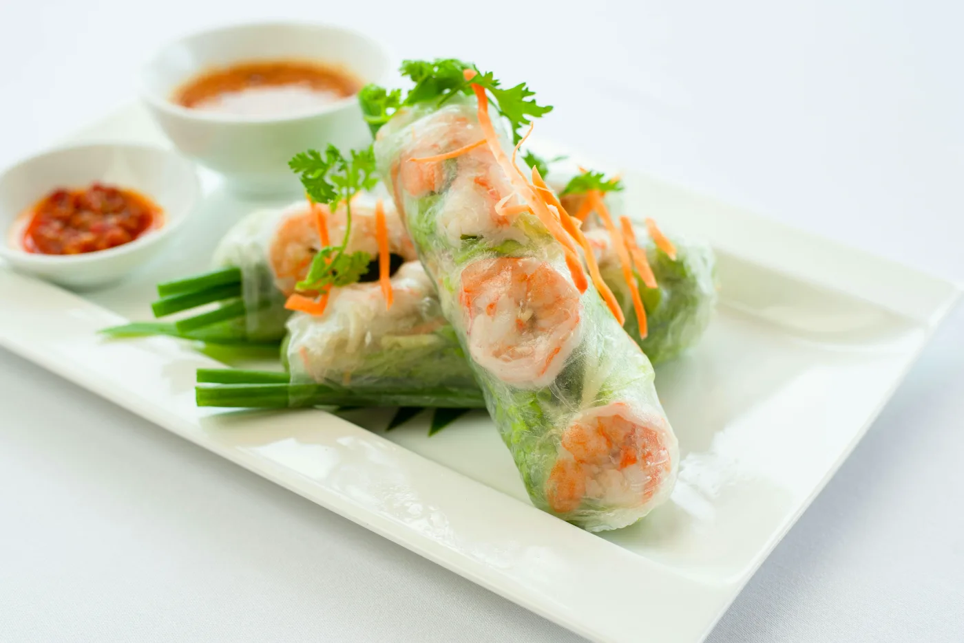 Vietnamese spring rolls with shrimp, served with fresh vegetables and a spicy soy dip for the summer party.