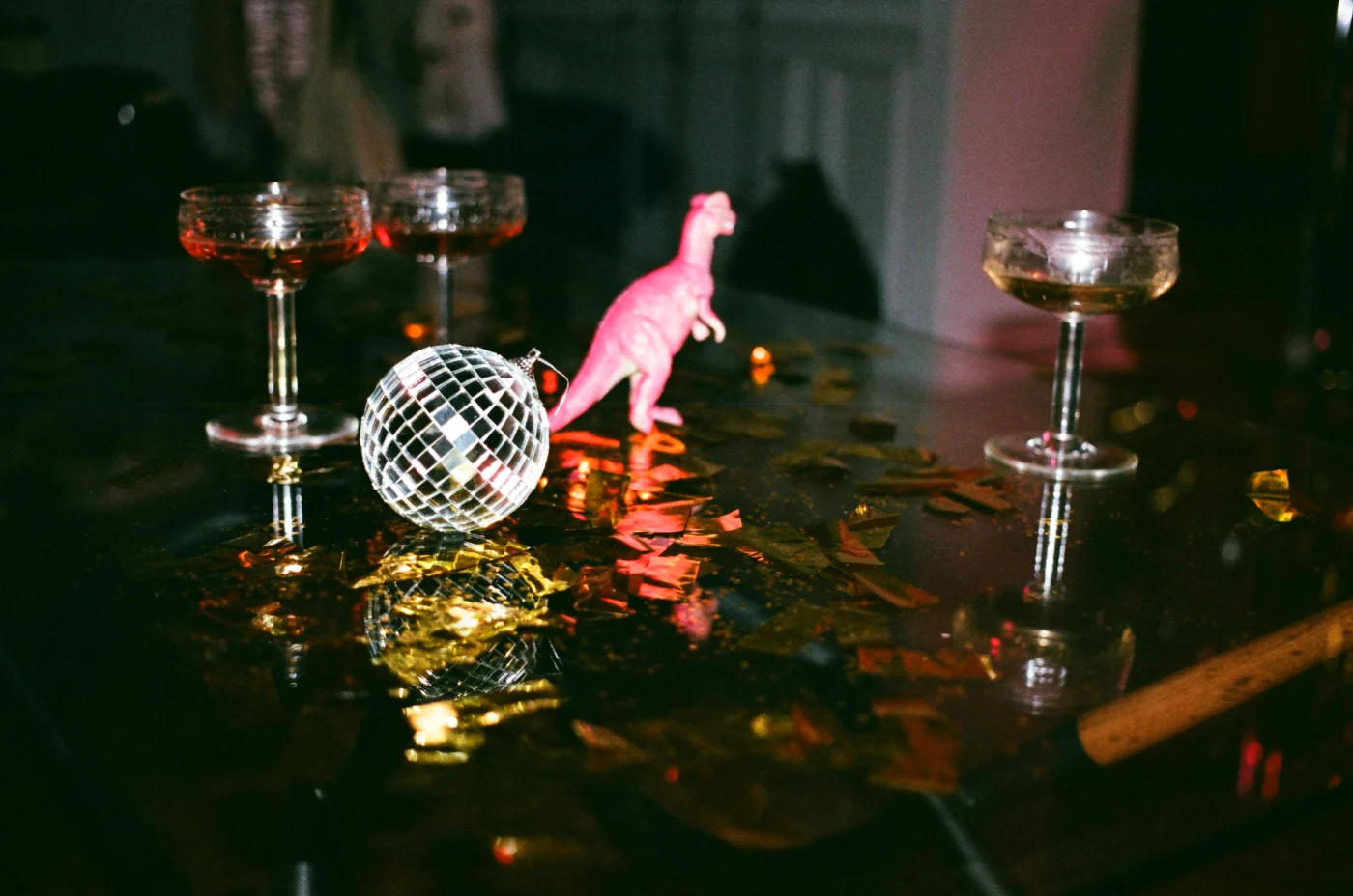 Festlig borddekoration med cocktailglas og en diskokugle, der skaber en livlig stemning til en fødselsdagsfest.