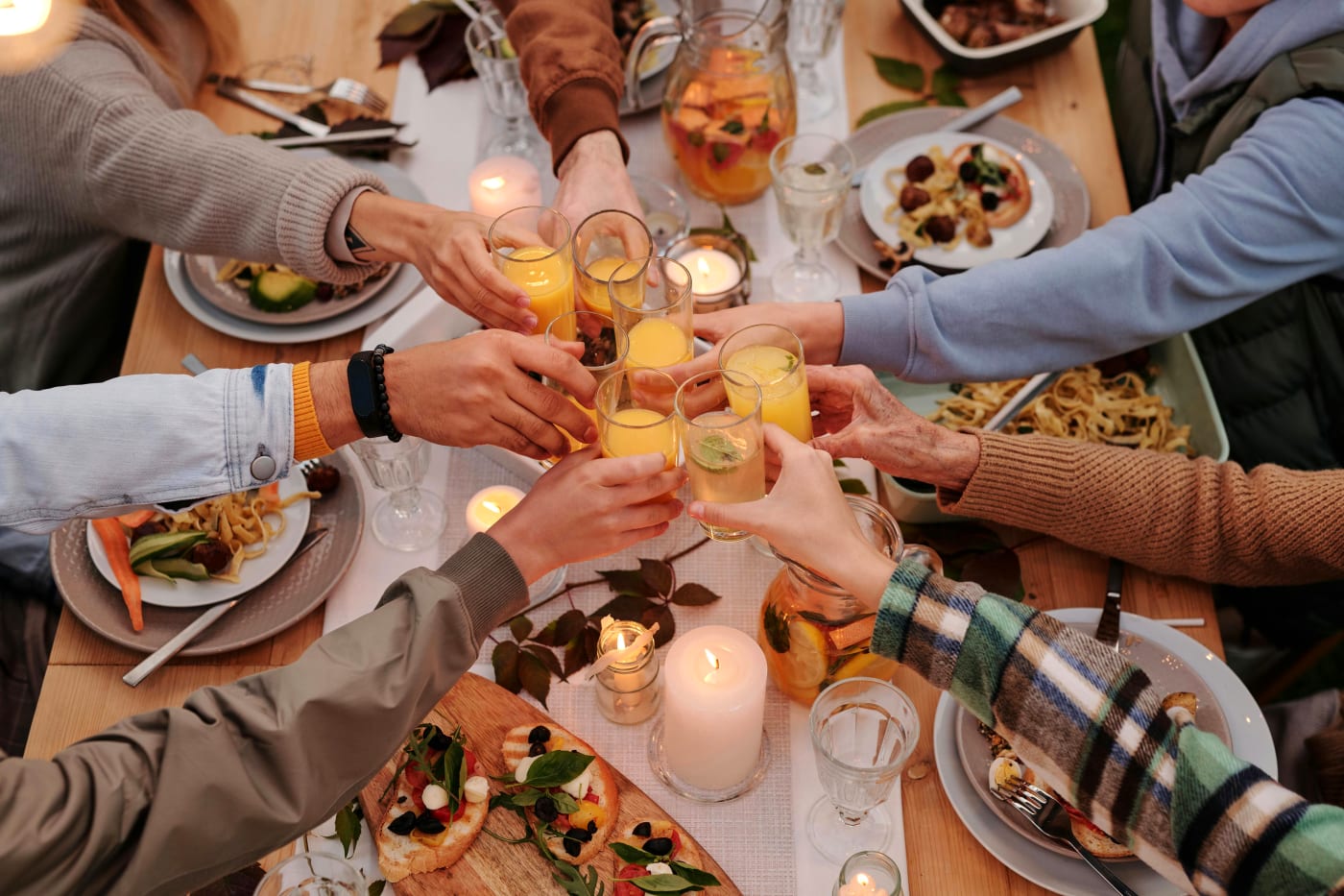 Familie samlet omkring et bord til pinsefrokost med friske forårsretter og hyggelig stemning.