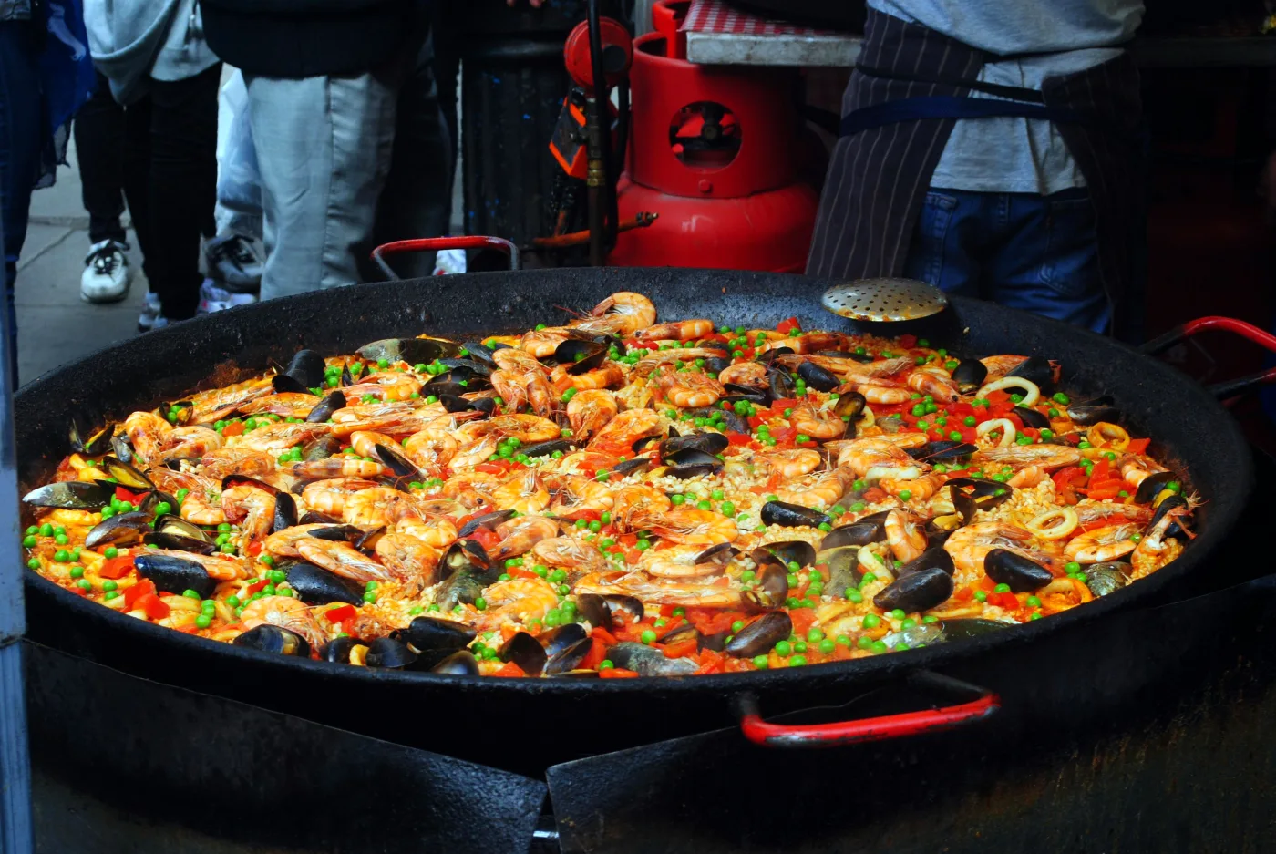 Authentic Spanish paella with seafood, mussels, and vegetables in a large paella pan, highlighting Spanish food culture and the essence of the recipe.
