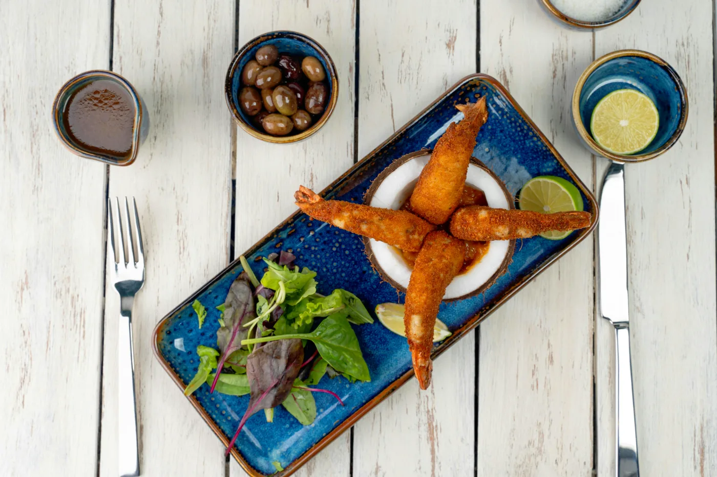 Fisk og skaldyr serveret med en grøn salat og citron, perfekt komplement til smagfulde fiskeretter.
