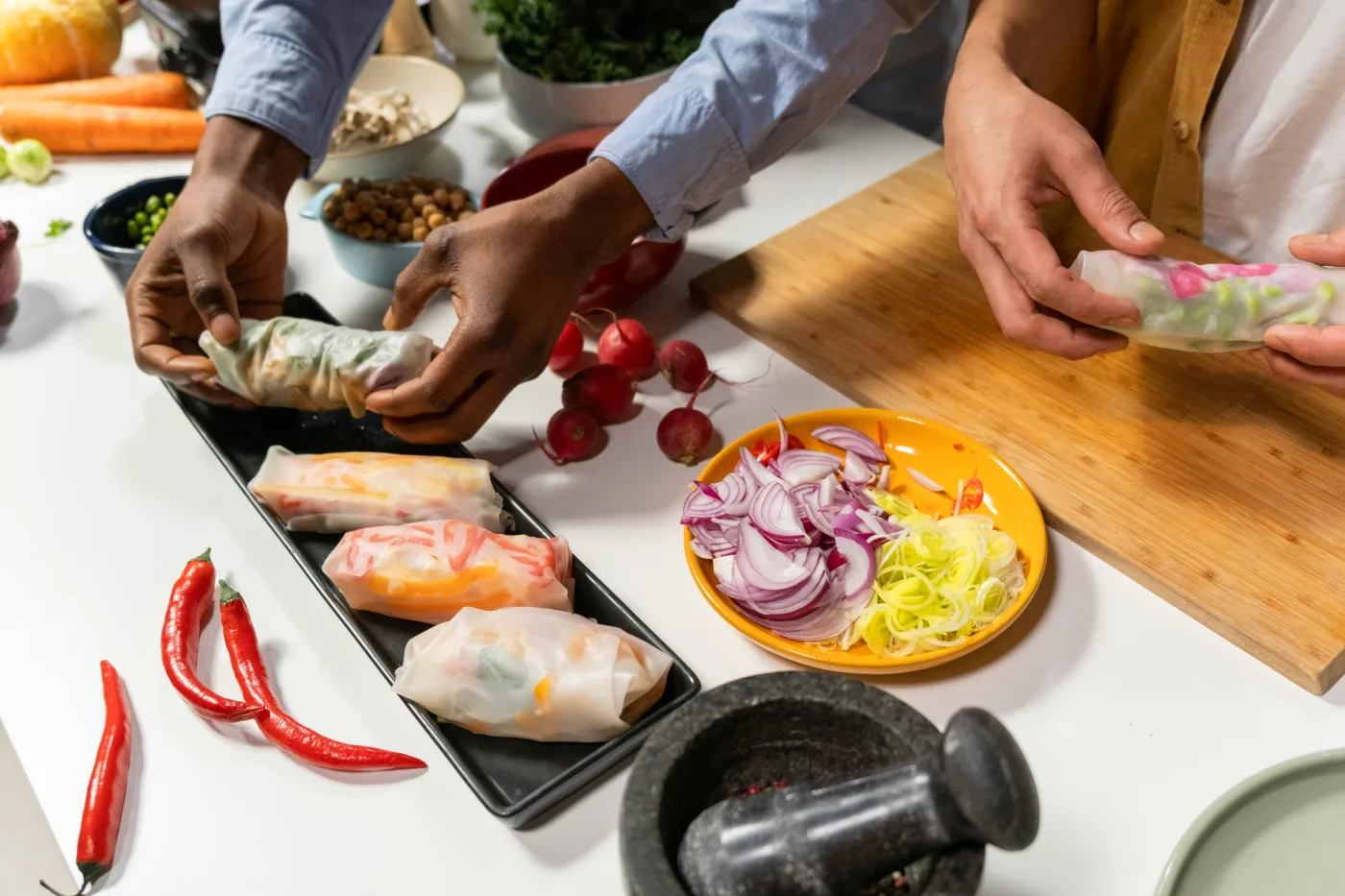 Vegan appetizers prepared with fresh vegetables on a bright kitchen counter.