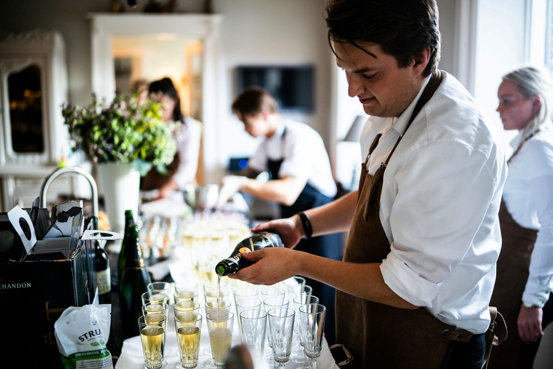 Professional chef pours champagne at the confirmation party, focus on quality and convenience.