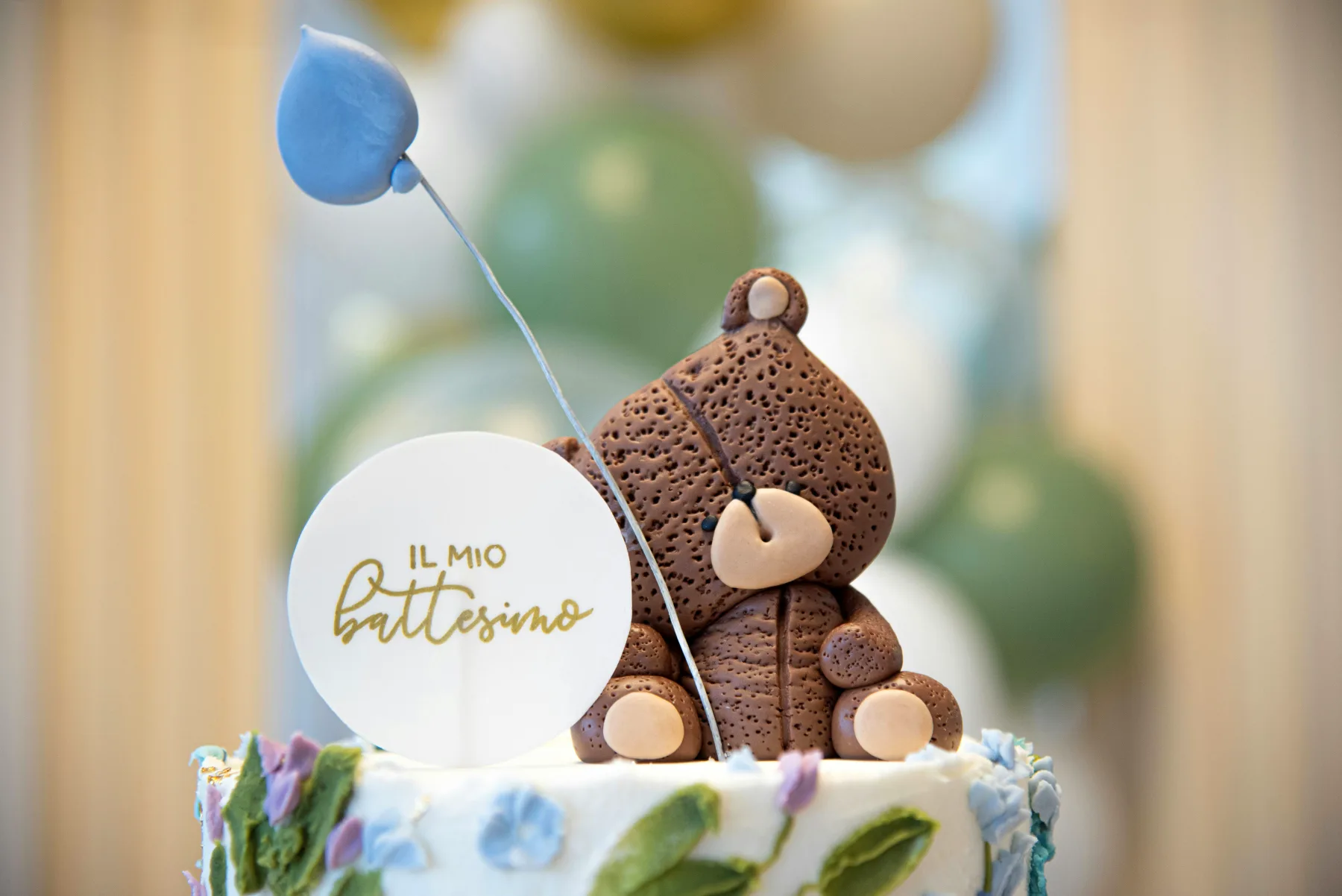 Christening cake with teddy bear decoration, symbolizing festivity and personality in christening planning.