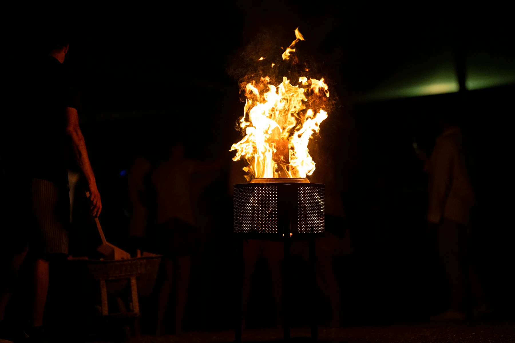 Sankt Hans bål i skumringen med folk omkring, perfekt til midsommerfest og grillmad.