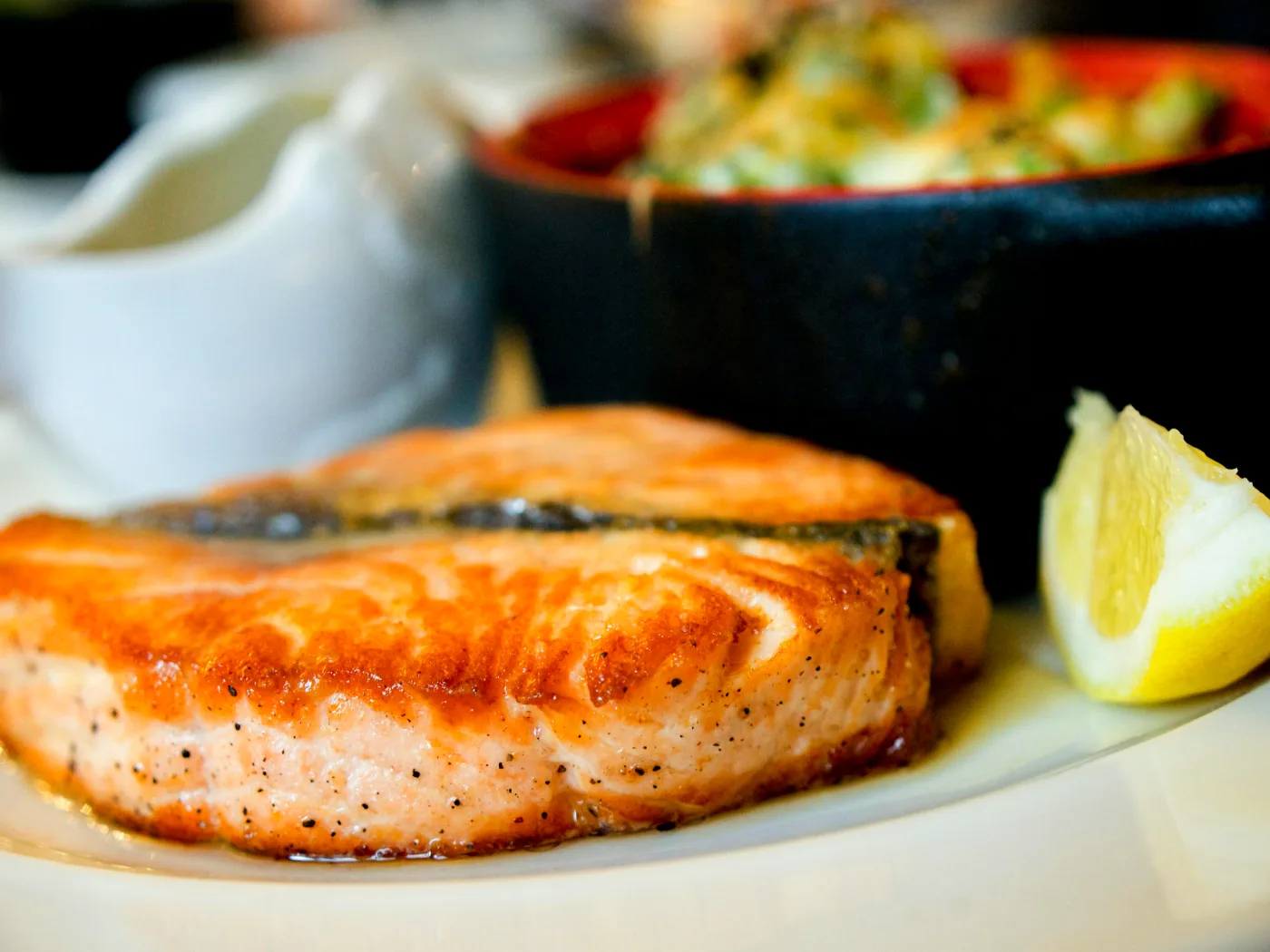Lækker lækker laks serveret med citron skildrer sundhedsmæssige fordele ved fisk og skaldyr i kosten med fokus på omega-3, vitaminer og proteiner.