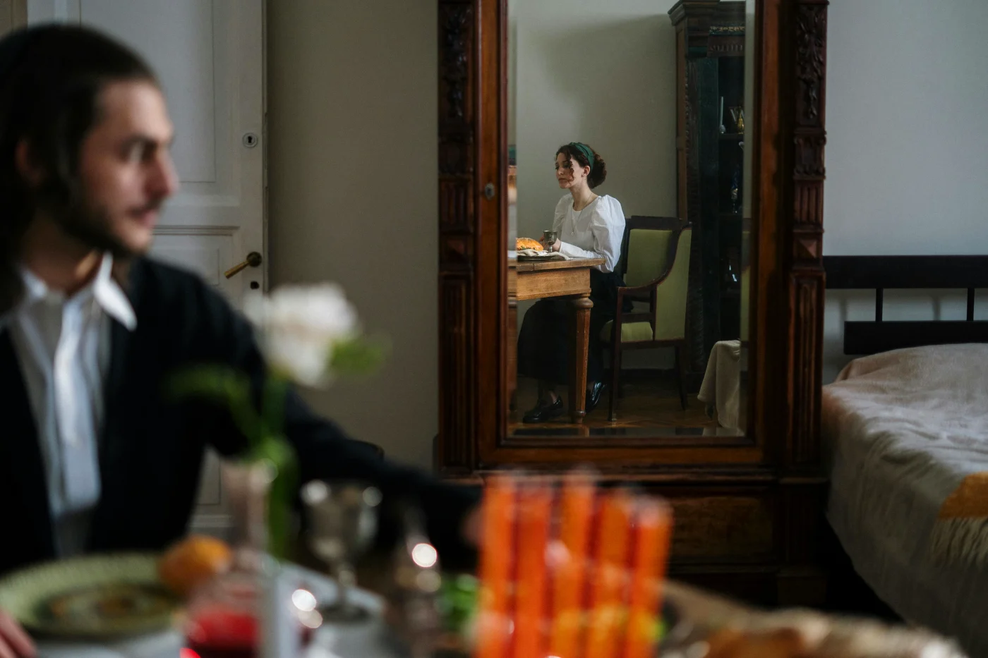 Intimate homemade dinner table with reflection of a woman enjoying a private dining experience.