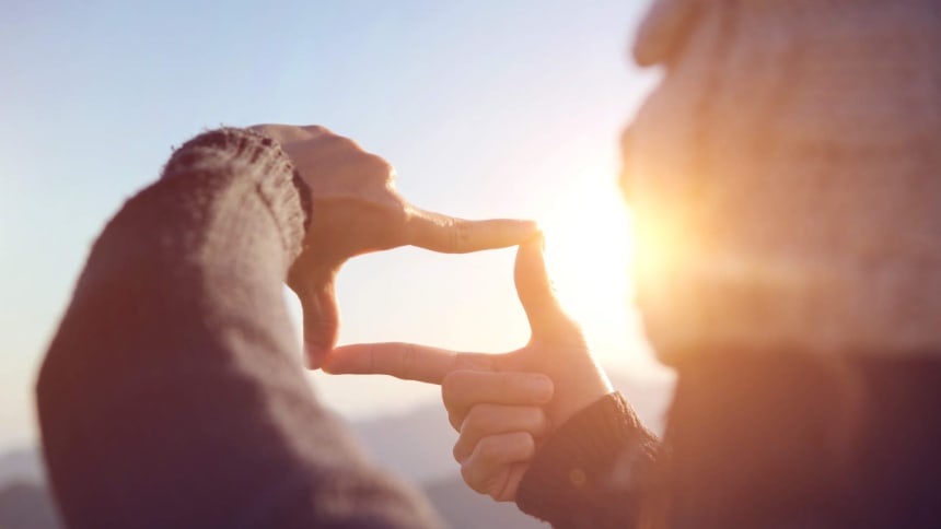 Frau_legt_ihre_Finger_auf_einem_Berg_in_einer_rahmenden_Geste_zusammen