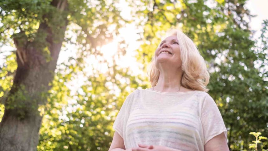 Frau_schaut_zuversichtlich_in_den_Himmel_im_Wald