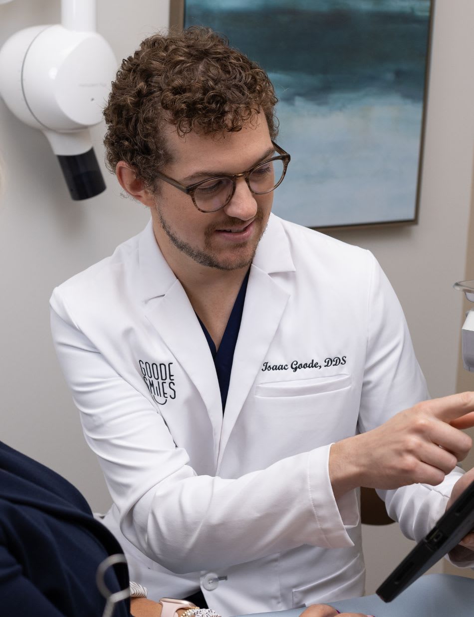 A dentist showing a seated patient a tablet